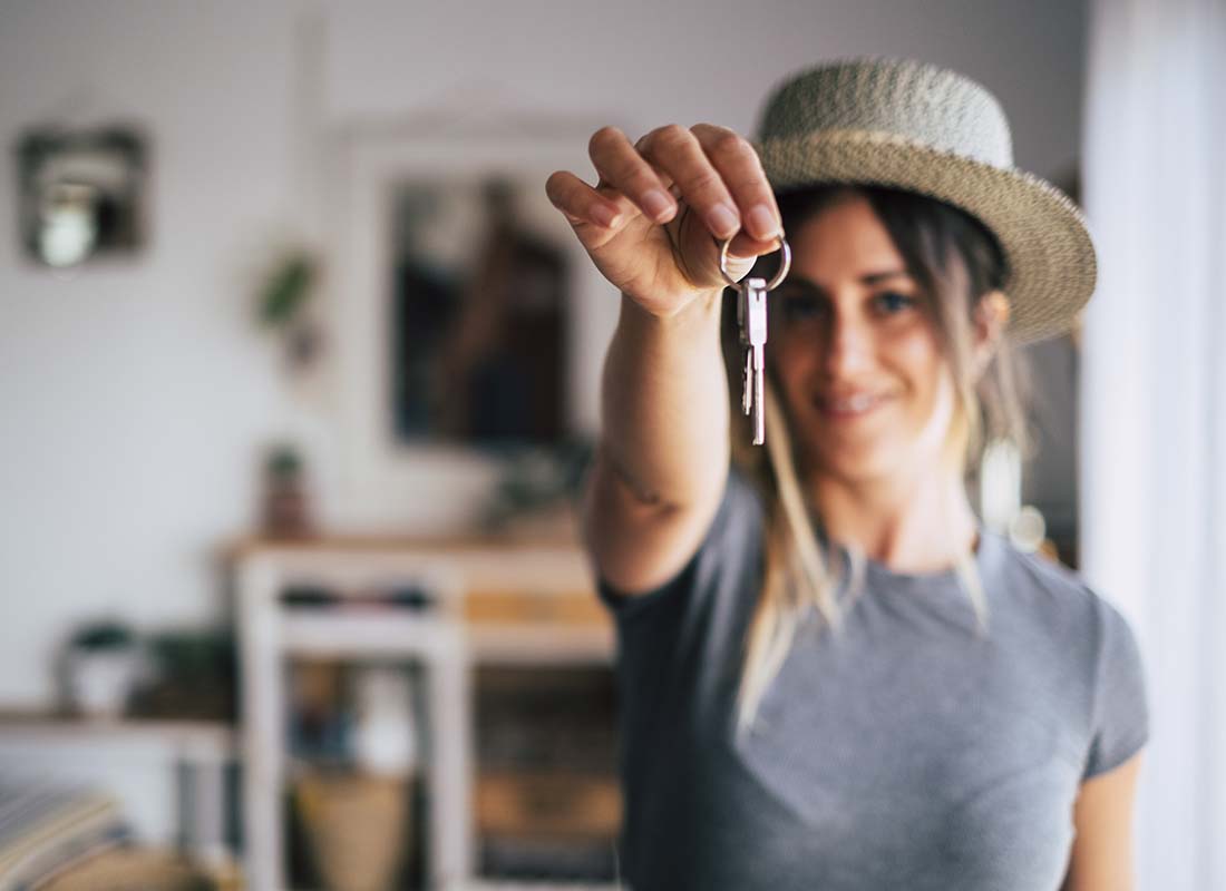 Renters Insurance - Close-up Blurred Image of a Happy Female Tenant Proudly Displaying House Keys in Focus as She Moves Into Her First Apartment