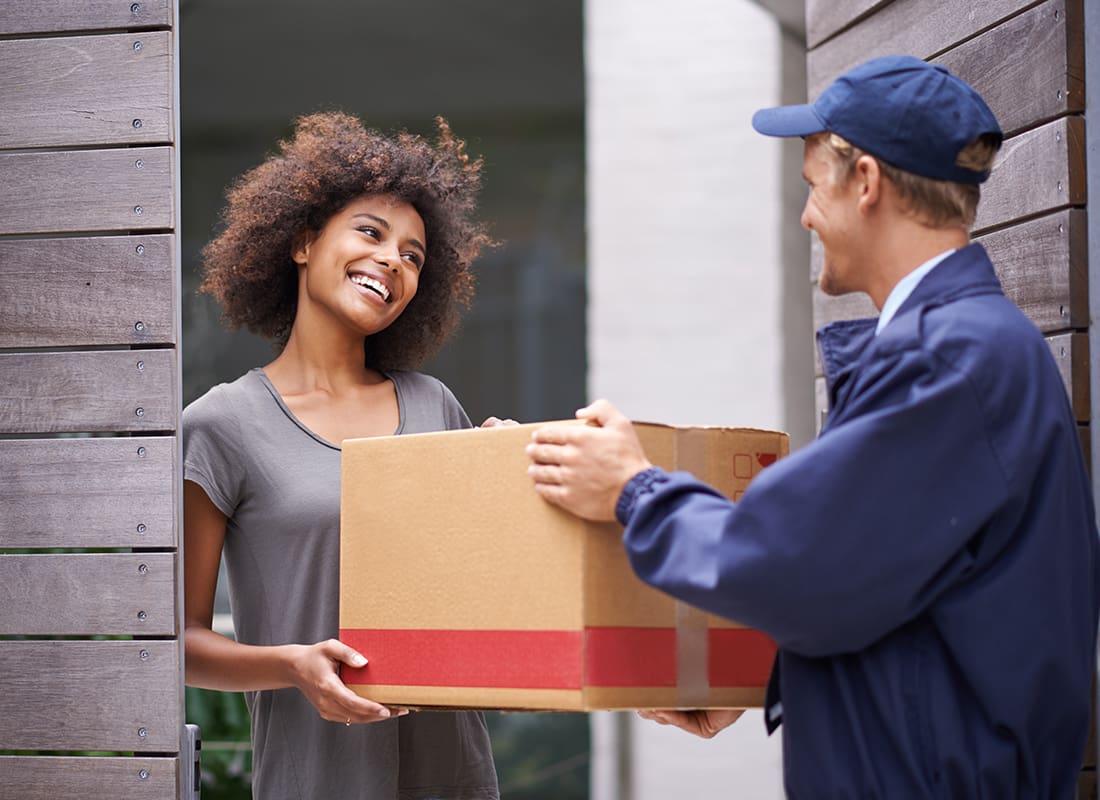 Business Insurance - Delivery Man Handing a Package to a Woman